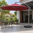 Dù lệch tâm tán tròn đỏ đô, trụ bên phải và đế thấp trên sân khô gần khu có mái