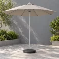 Ô chính tâm tán xám be với trụ giữa màu bạc và chân đế đen tròn trong sân