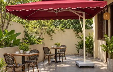 Minh họa ô lệch tâm tán vuông đỏ rượu với đế đặt cạnh khu bàn ngoài trời
