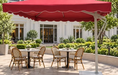 Minh họa ô lệch tâm tán đỏ với trụ lệch bên che hai bàn cafe nhỏ tại sân lát gạch