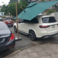 Ô lệch tâm tán xanh ở góc nghiêng bên cạnh một chiếc ô tô