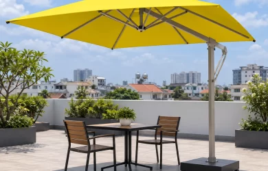 Ô lệch tâm tán vuông màu vàng, trụ bên và đế thấp đặt cạnh bàn ghế trên sân thượng