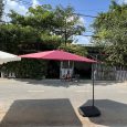 Ô lệch tâm tán đỏ với trụ bên cạnh và chân đế trên sân