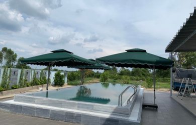 Hai ô lệch tâm tán xanh đặt gần hồ bơi